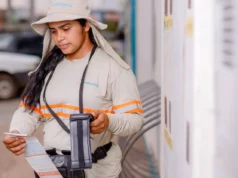 uma Auxiliar Comercial (Leiturista) da energisa fazendo a medição de um contador de energia